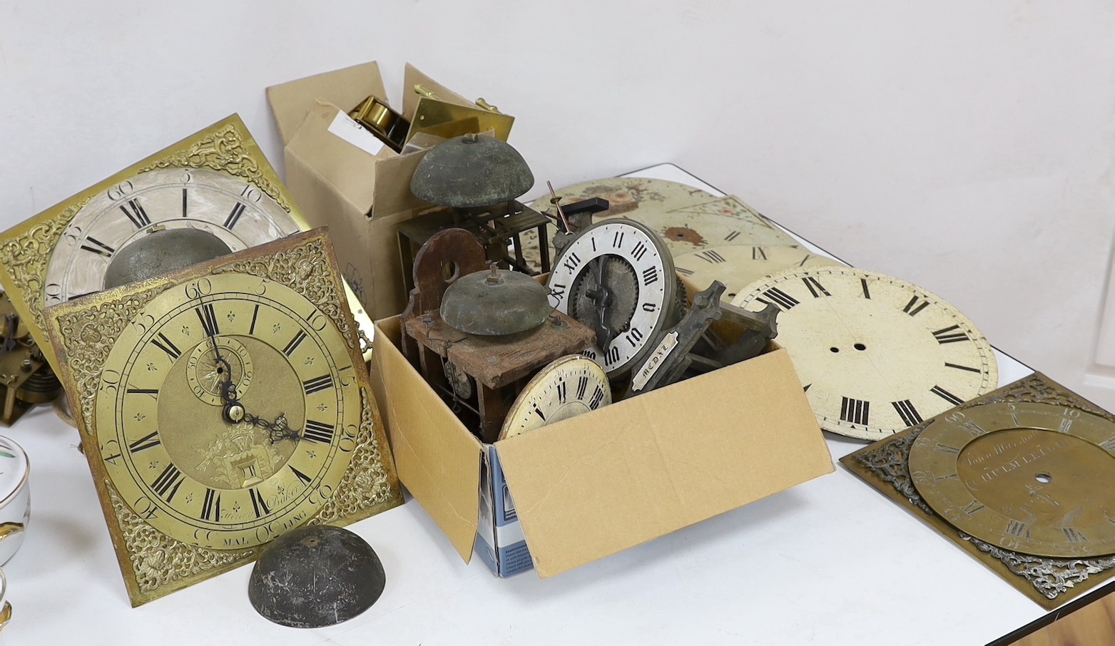 A large quantity of clock parts, to include movements, dials etc., including a John Marshall of Chulmleigh clock face